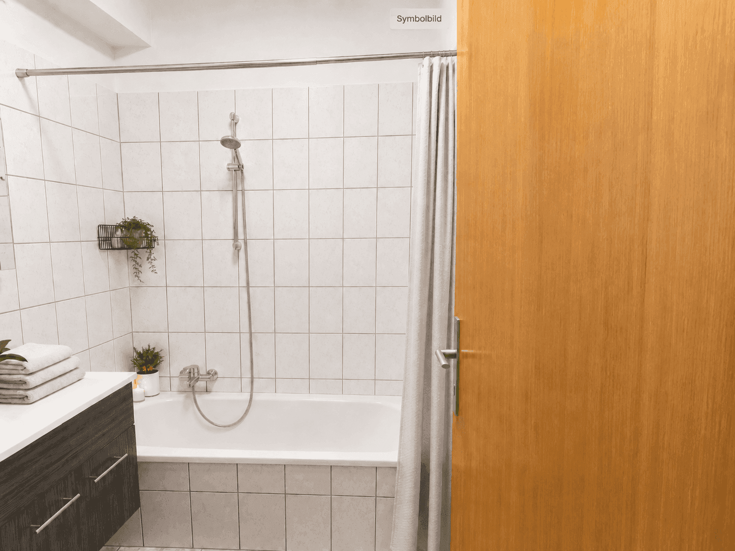 Helles Badezimmer mit Badewanne, Duschvorhang und weißen Fliesen an den Wänden.