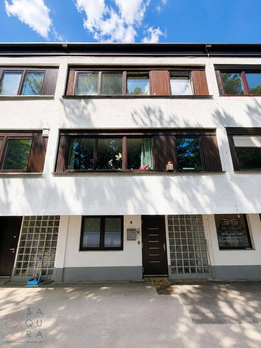 Detailansicht der Gebäudefassade mit Eingängen im Erdgeschoss und Fensterfronten.