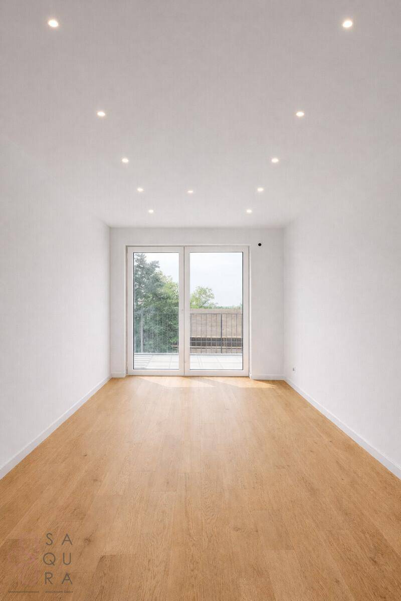 Heller, leerer Raum mit Holzboden und Schiebetür zum Balkon, ideal für individuelle Einrichtung.