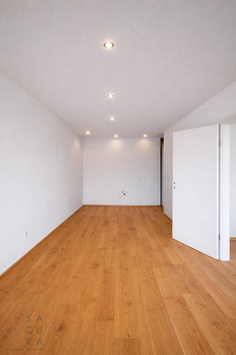 Leerer Raum mit hellem Parkettboden und Einbaustrahlern in der Decke, bereit zum Einzug.