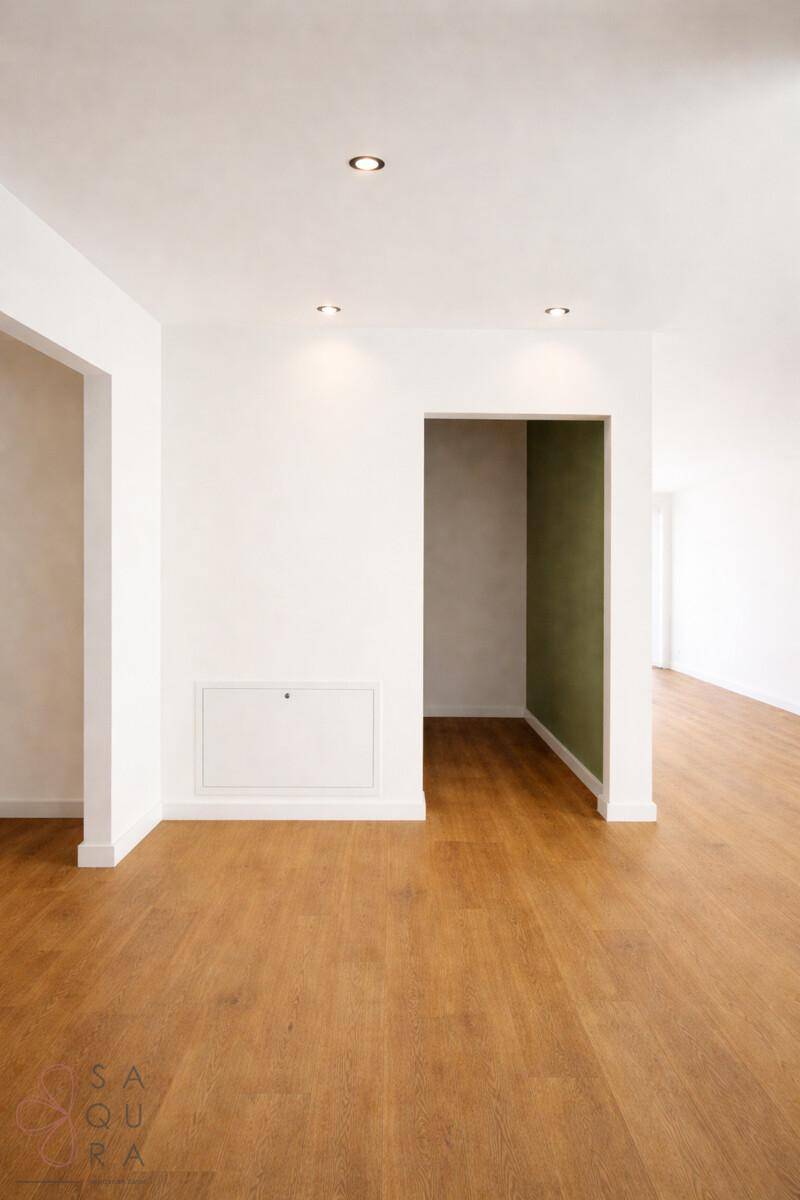 Heller Flurbereich mit Holzboden und einem farbigen Akzent an der Wand, verbindet die Räume.