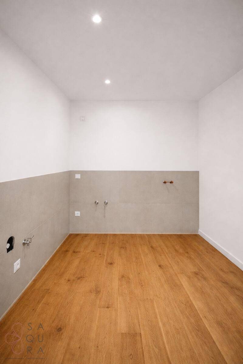 Funktionaler Raum mit Anschlüssen und halbhohen Fliesenwänden, ideal als Hauswirtschaftsraum.