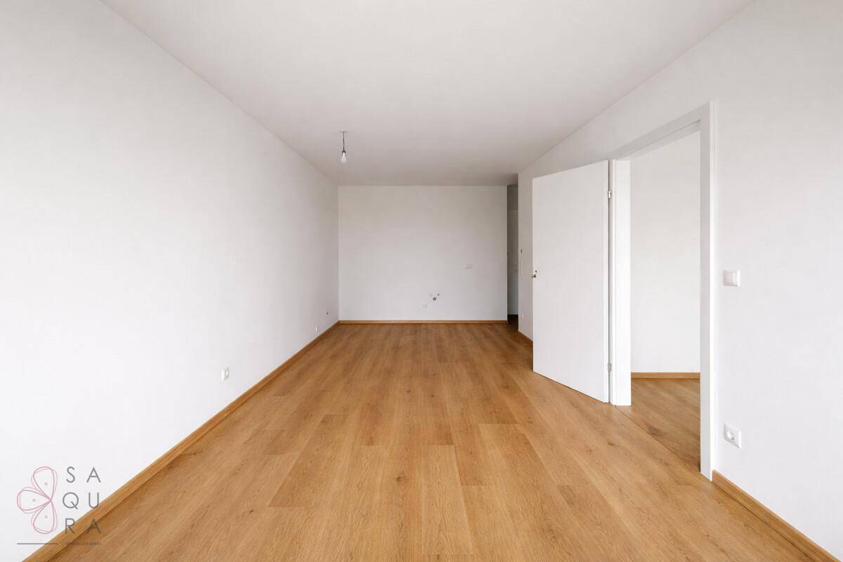 Geräumiger, heller Raum mit Parkettboden und weiß gestrichenen Wänden, bietet viel Platz.