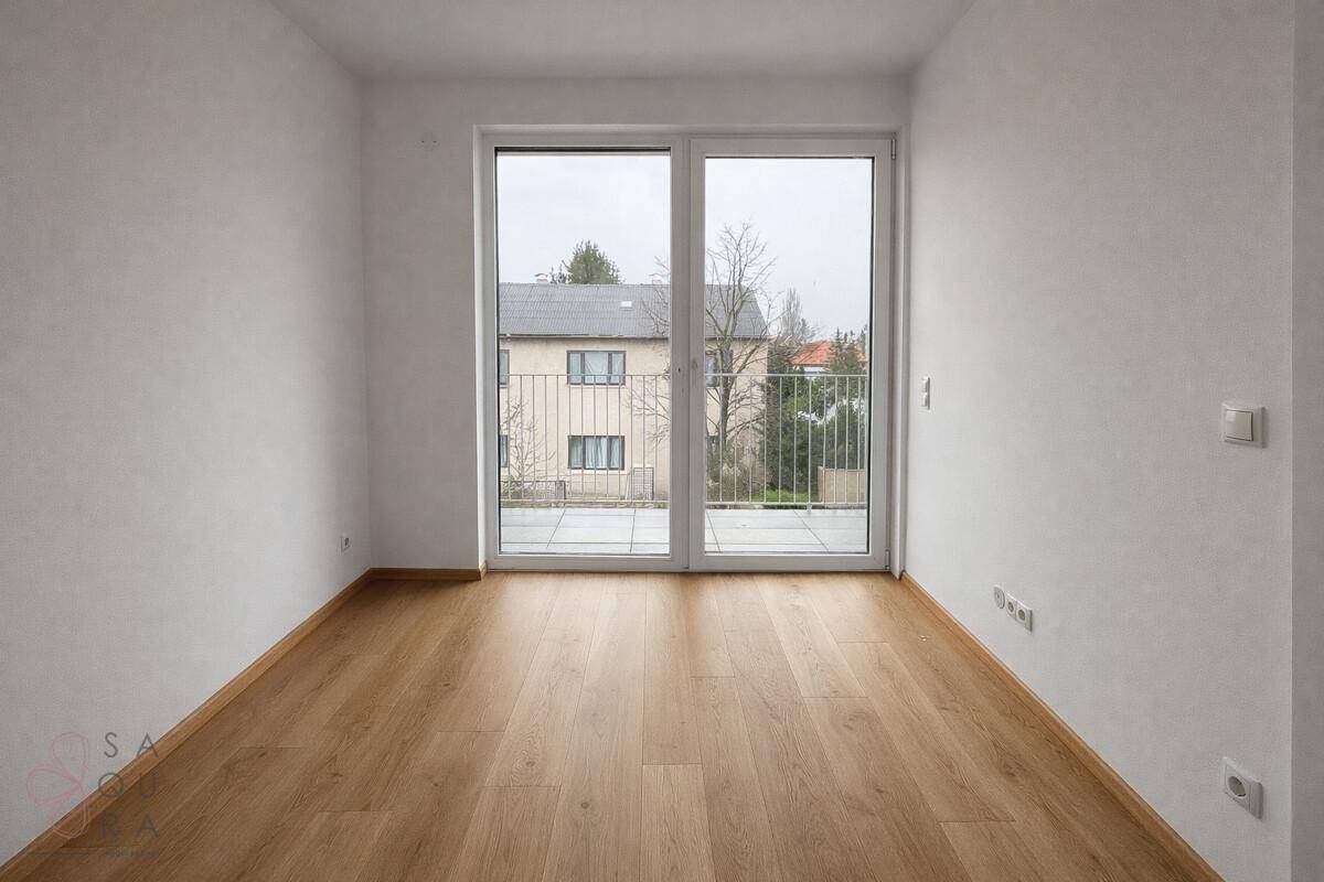 Heller Raum mit Zugang zu einem kleinen Balkon und Blick auf die Nachbarschaft, bietet frische Luft.