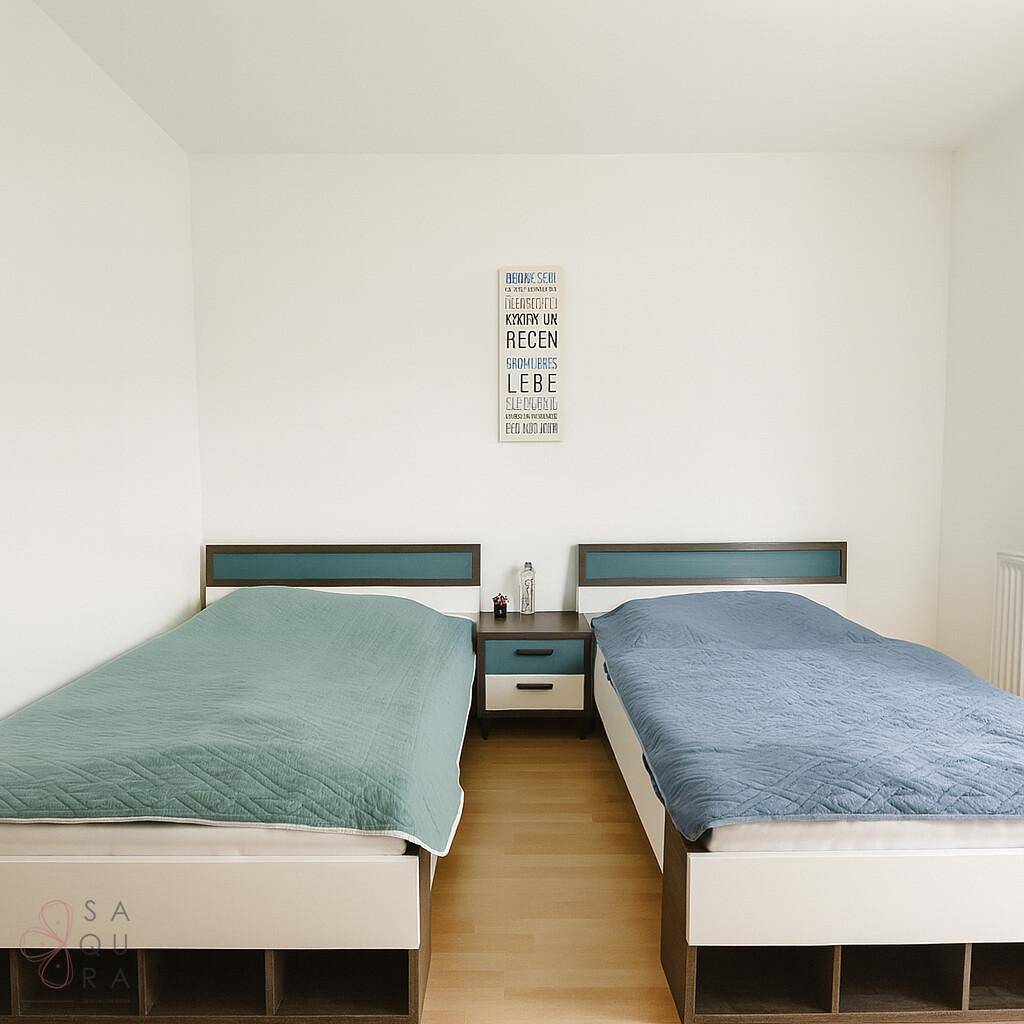 Schlafzimmer mit zwei Einzelbetten, Holzboden und minimalistischer Wanddekoration.