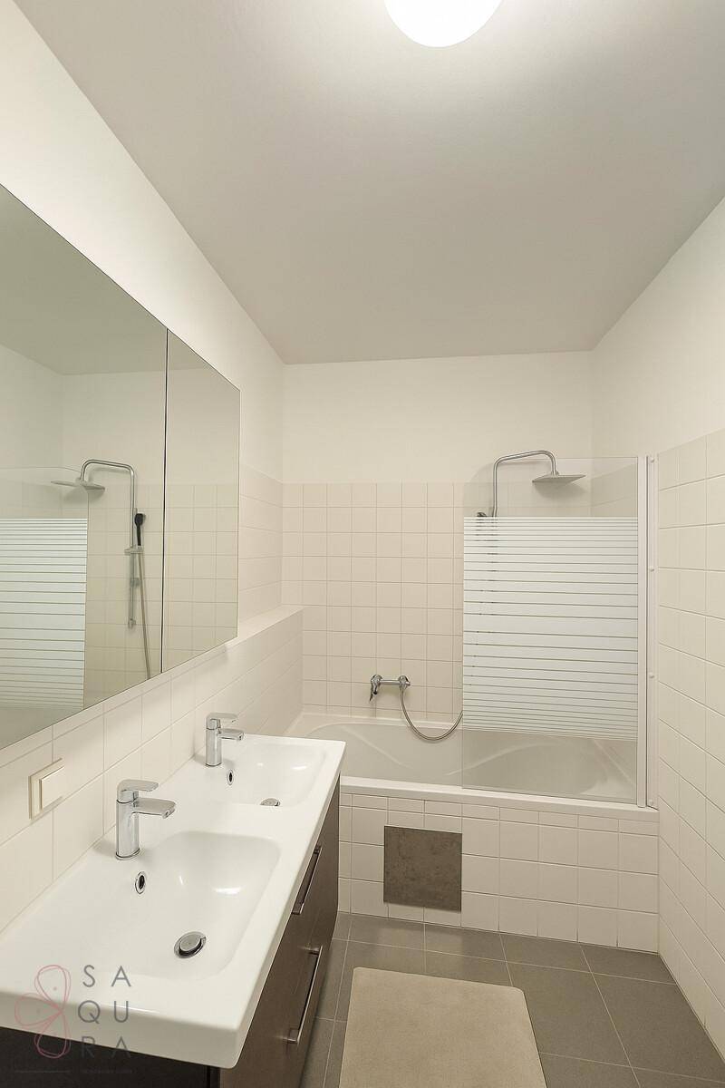 Modernes Badezimmer mit Badewanne, Doppelwaschbecken und Spiegelschrank.