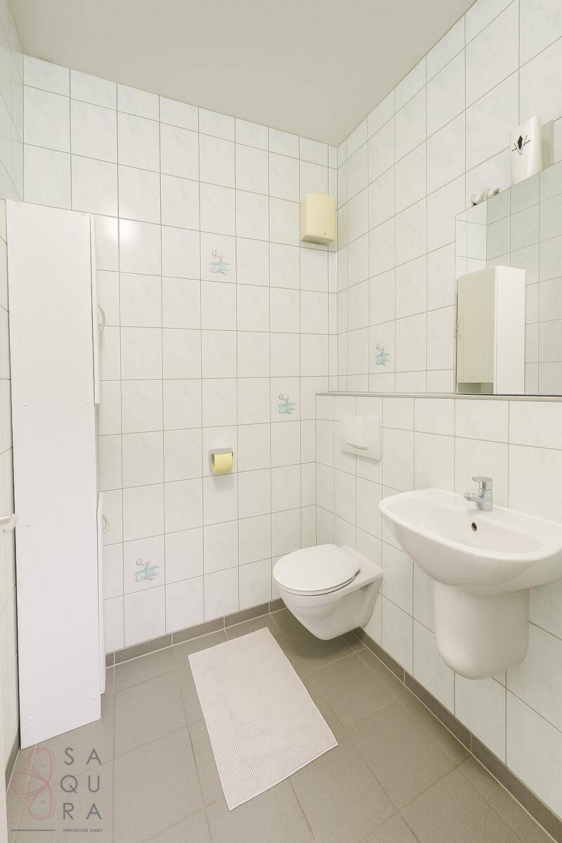 Modernes Gäste-WC mit Wand-WC, Waschbecken und weißen Fliesen.