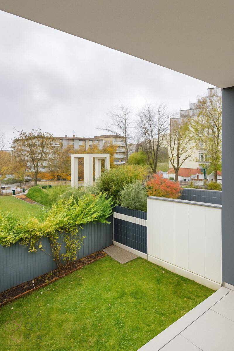 Kleiner privater Gartenbereich mit Rasenfläche und Blick auf die Wohnanlage.