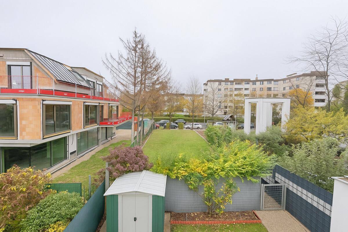 Gepflegter Gartenbereich mit Rasen, Gartenhaus und Blick auf die Umgebung.