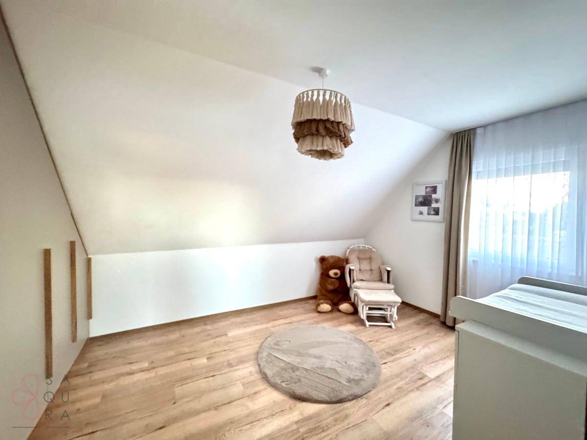 Helles Kinderzimmer im Dachgeschoss mit Holzboden und viel Platz zum Spielen.