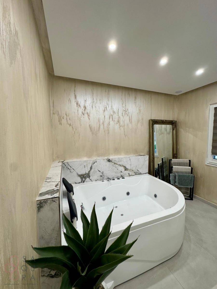 Modernes Badezimmer mit luxuriöser Eck-Whirlpool-Badewanne und stilvoller Wandgestaltung.