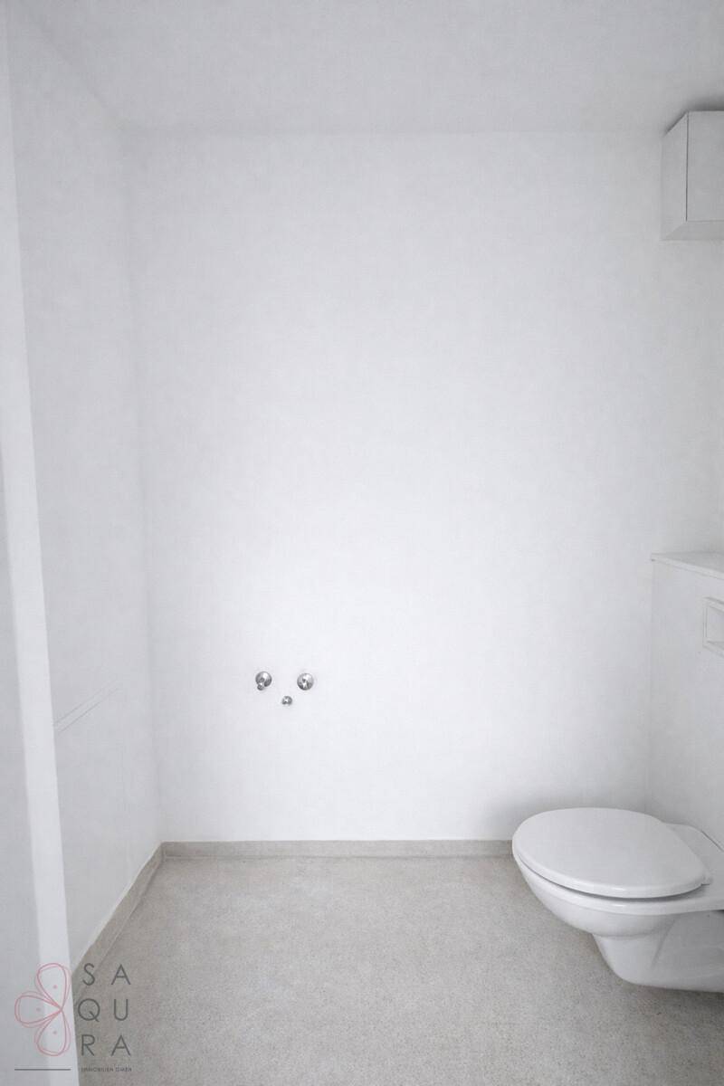 Kleines, helles Gäste-WC mit wandhängender Toilette und schlichten weißen Wänden.