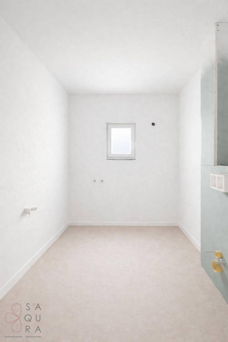 Kleiner Raum mit Fenster und sichtbaren Sanitäranschlüssen, ideal für ein Badezimmer.