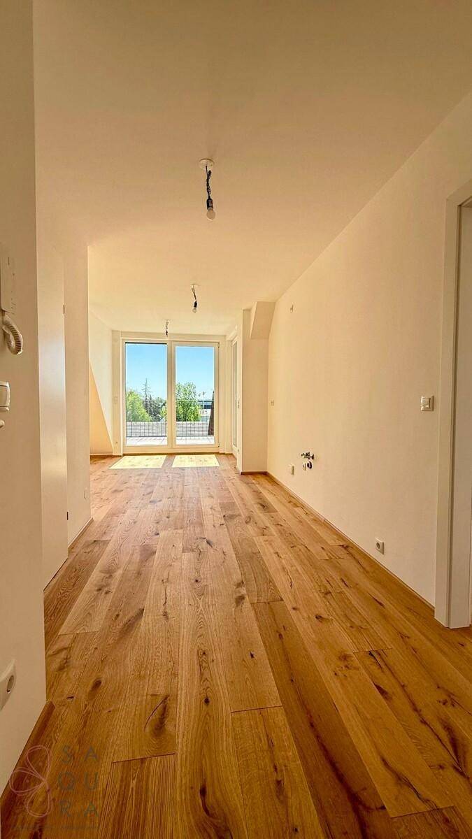 Heller Flur mit Holzboden und großen Fenstern, die einen weiten Blick auf die Umgebung bieten.