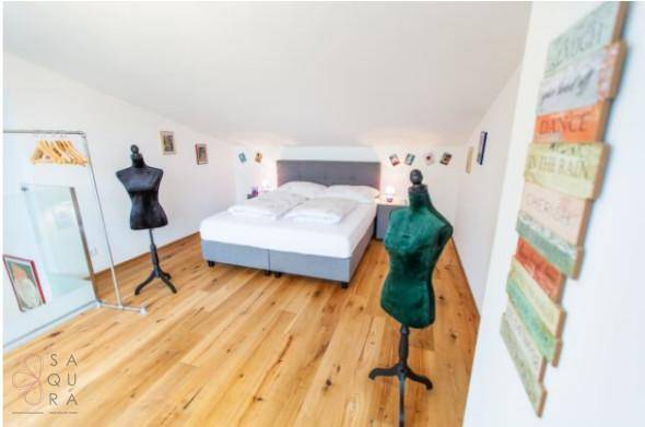Helles Schlafzimmer im Dachgeschoss mit Holzboden und moderner Dekoration.