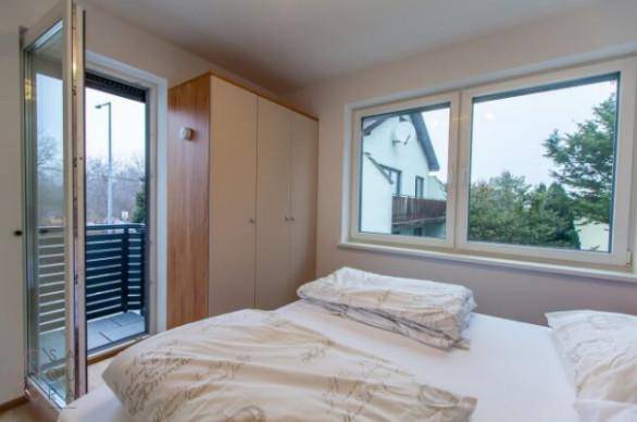 Schlafzimmer mit Zugang zu einem kleinen Balkon und Blick auf die Umgebung.