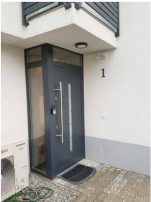 Moderner Hauseingang mit dunkler Tür und Hausnummer 1.