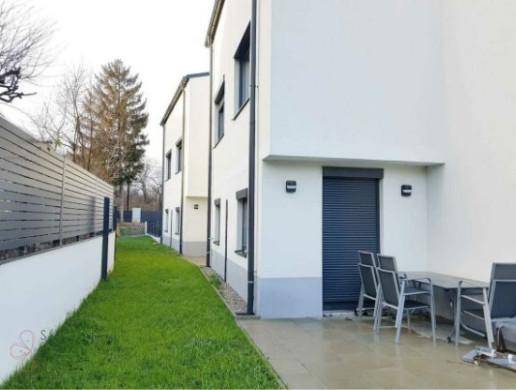 Terrasse mit Gartenmöbeln und Rasenfläche hinter dem Haus.