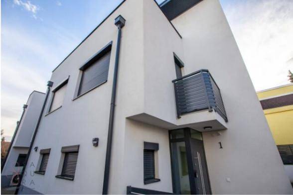 Ansicht der modernen Hausfassade mit Balkon und Eingangsbereich.