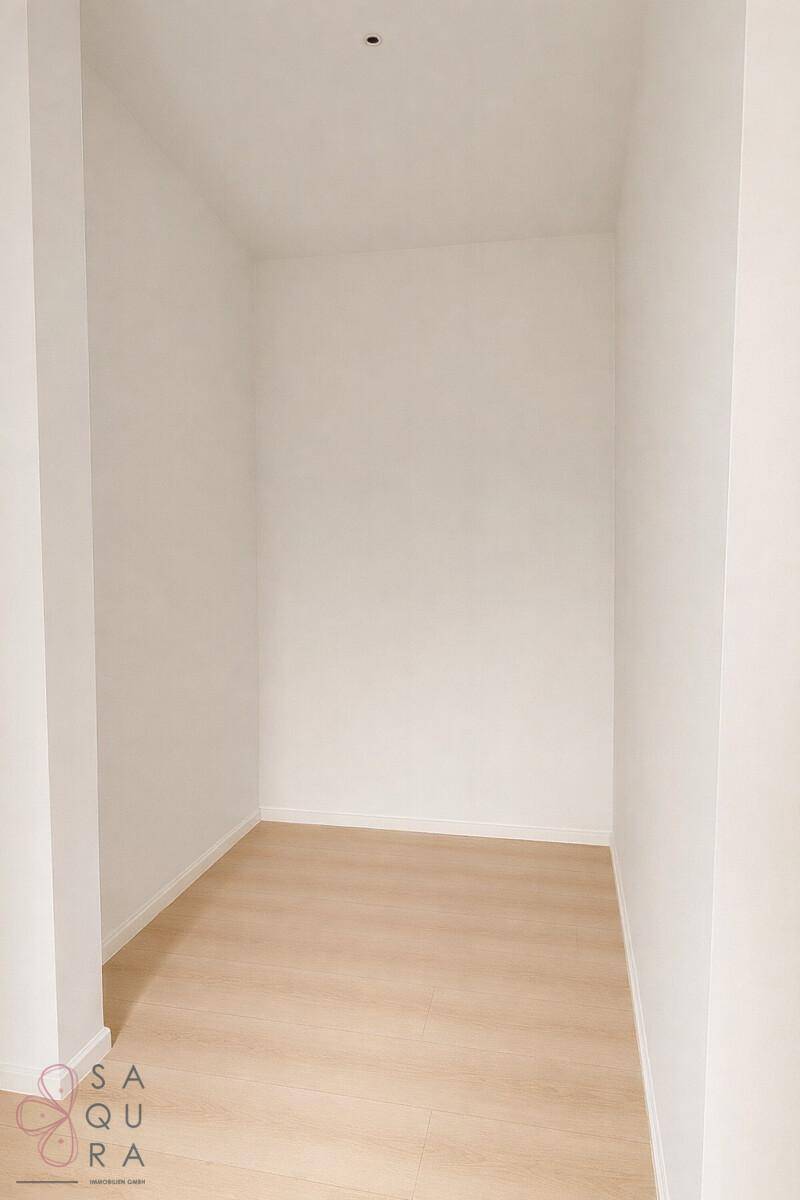 Ein kleiner, leerer Raum mit hellem Laminatboden, ideal als Abstellraum oder begehbarer Kleiderschrank.