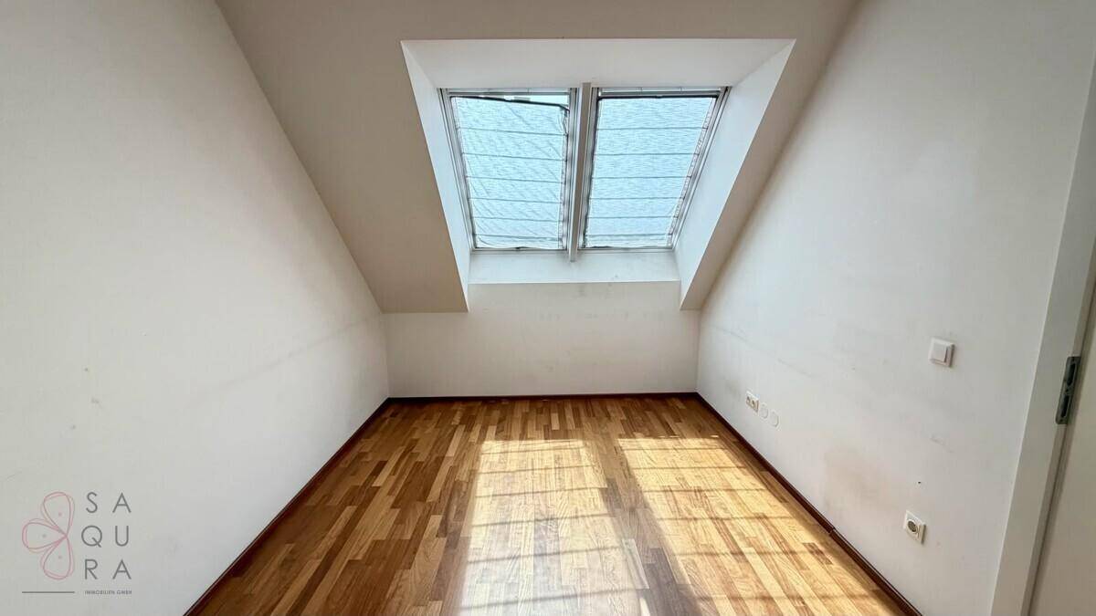 Helles Zimmer mit Holzboden und zwei großen Dachfenstern, ideal als Schlafzimmer oder Büro.