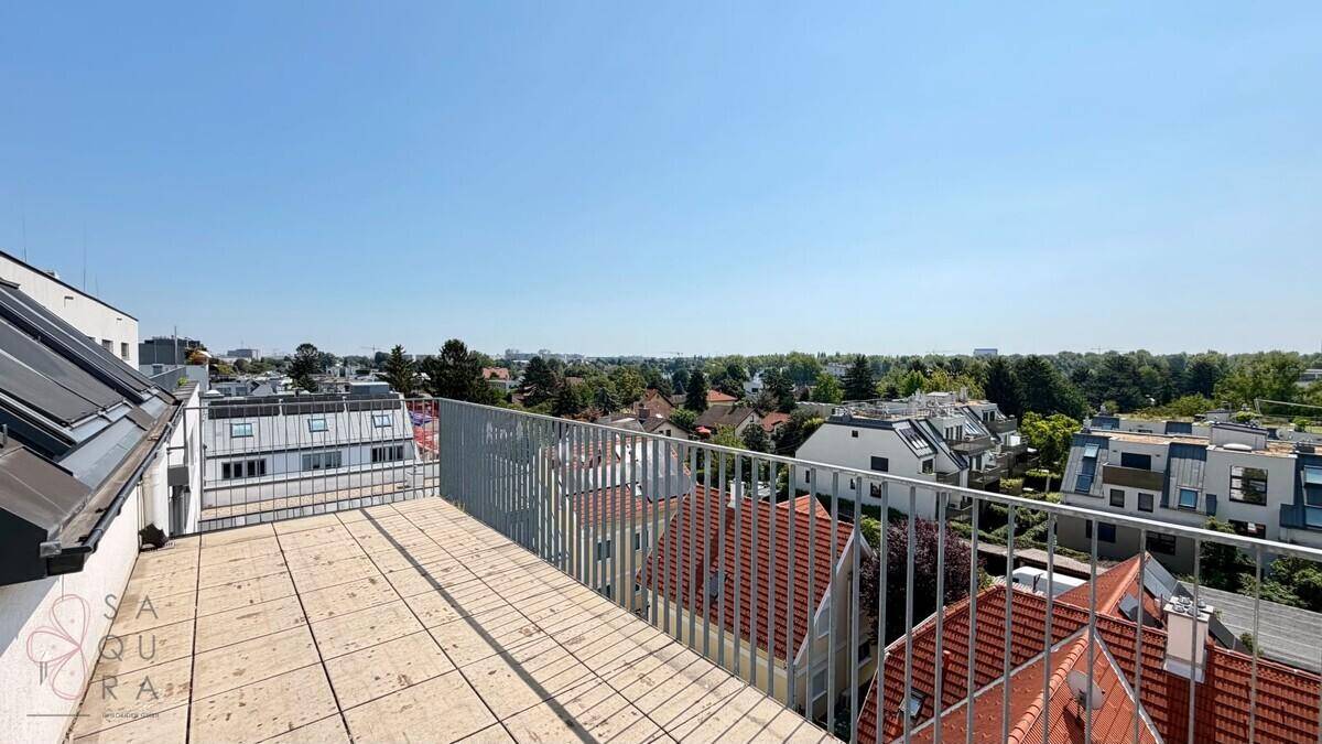Große Dachterrasse mit Fliesenboden und weitem Blick über die Stadt und Umgebung.