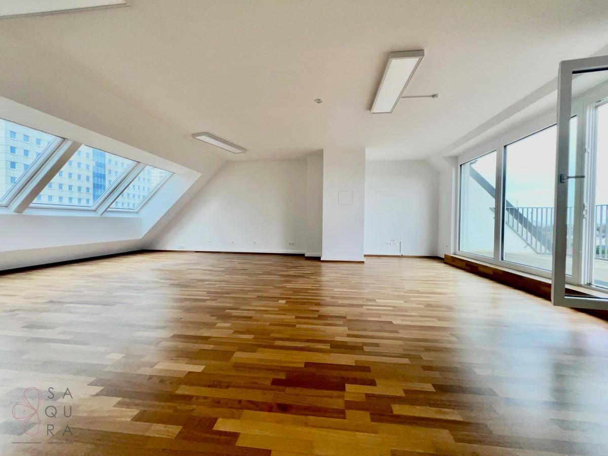 Helles, leeres Zimmer mit Holzboden und großen Dachfenstern, bietet viel Gestaltungspotenzial.