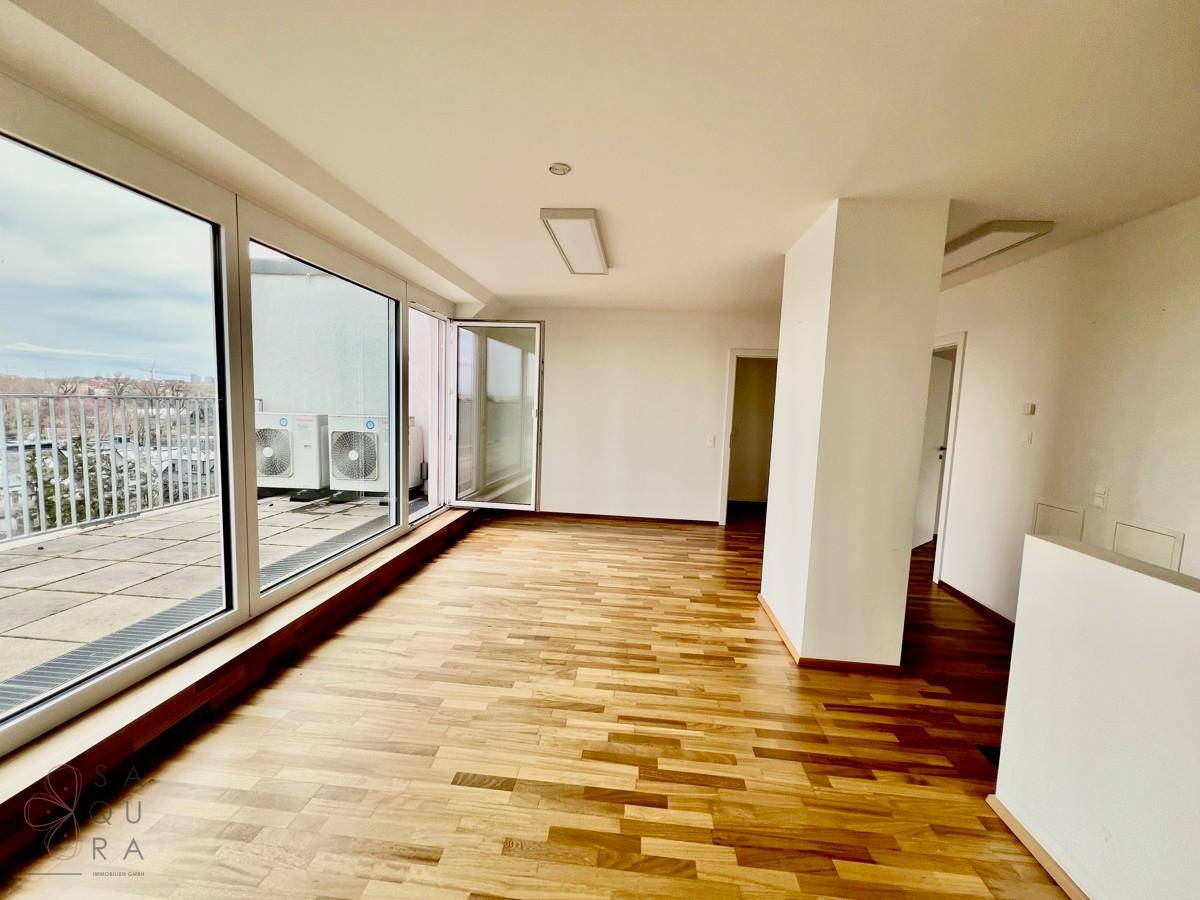 Heller Wohnraum mit Holzboden und direktem Zugang zur Dachterrasse, inklusive Klimaanlage.