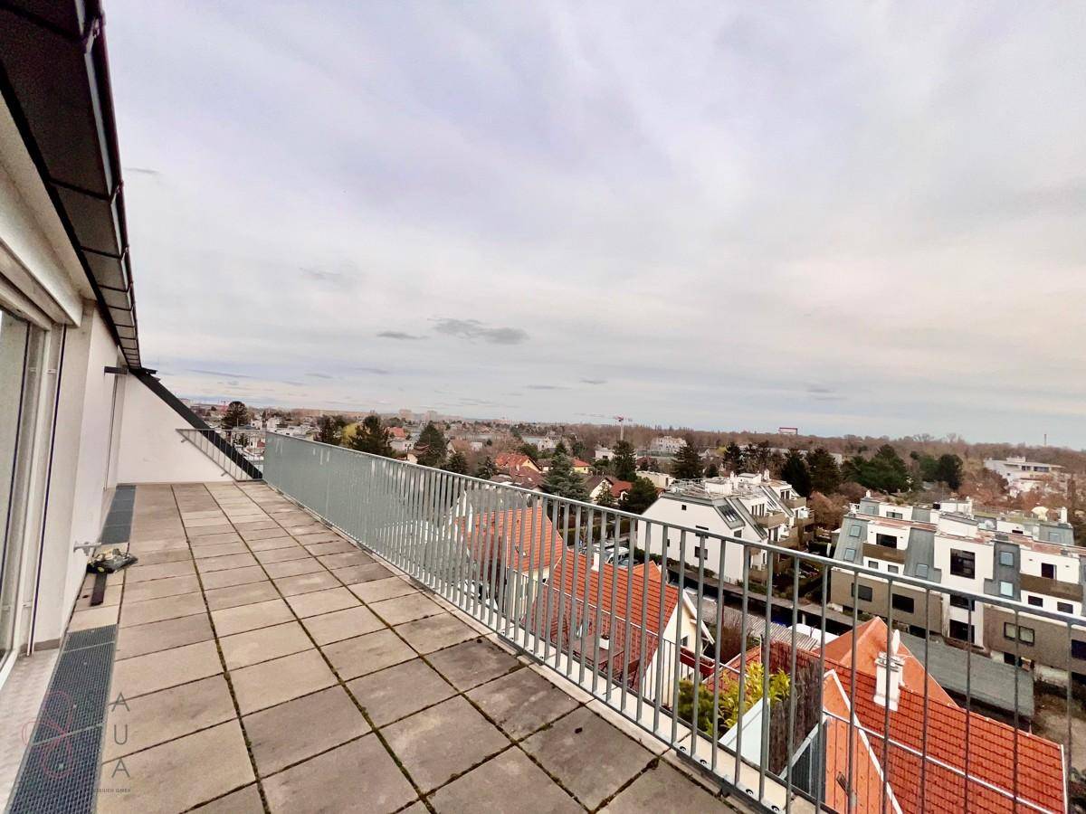 Weitläufige Dachterrasse mit Fliesenboden und Panoramablick über die Stadt und Umgebung.