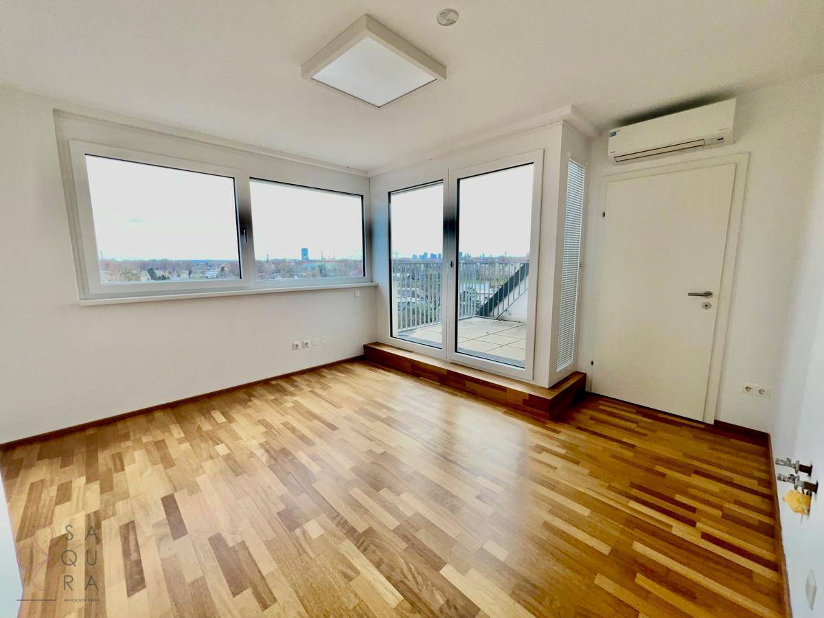 Helles Schlafzimmer mit Holzboden, Klimaanlage und Zugang zu einer kleinen Terrasse.