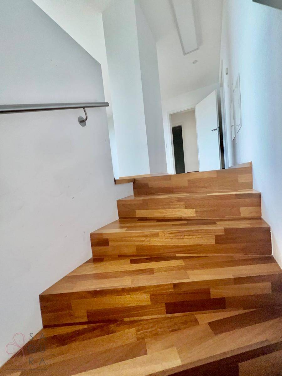 Detailansicht der Holztreppe mit Handlauf, verbindet die verschiedenen Ebenen des Hauses.
