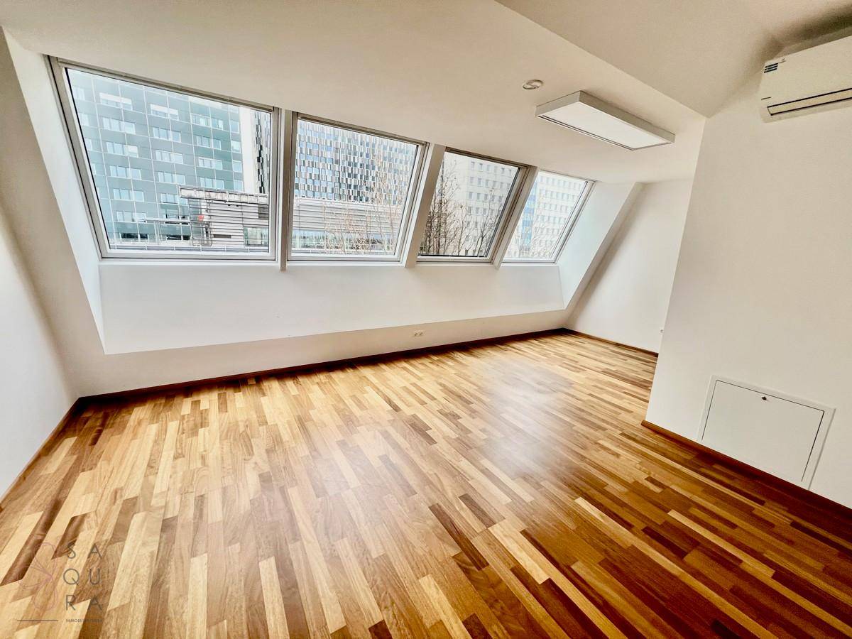 Helles Zimmer mit Holzboden, Klimaanlage und Dachfenstern, ideal als Schlafzimmer.