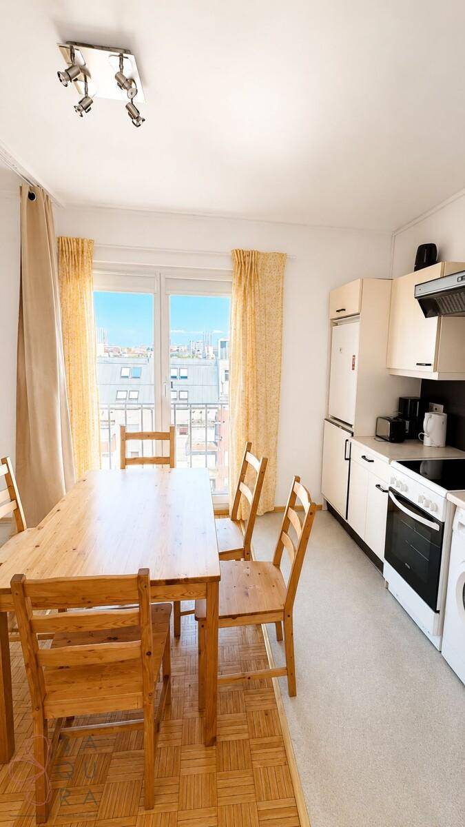 Heller Küchenbereich mit Esstisch und Zugang zum Balkon.