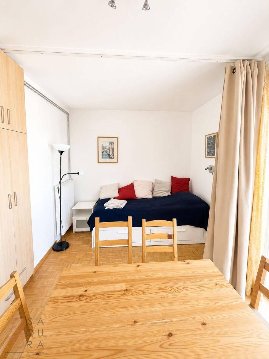 Multifunktionaler Raum mit Schlafbereich, Esstisch und Kleiderschrank.