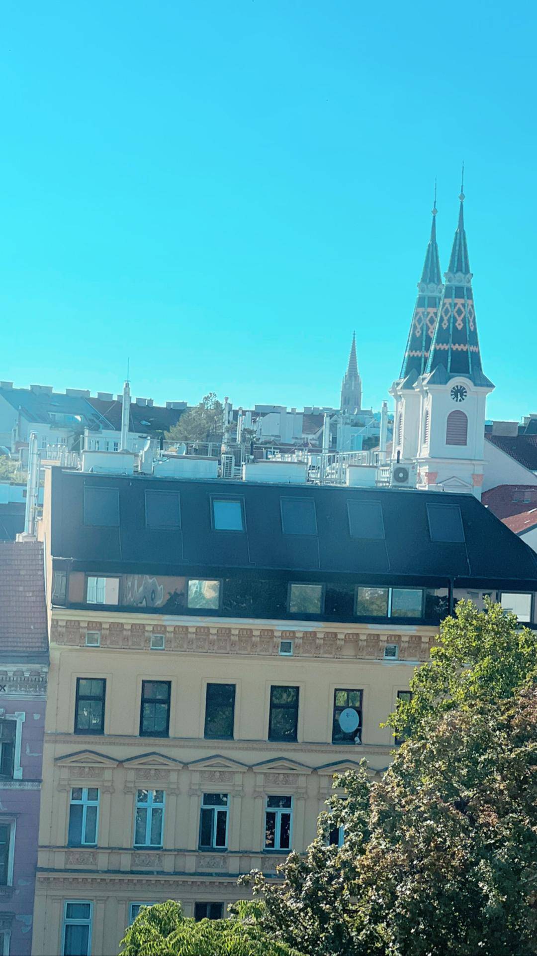 Stadtansicht mit historischen Gebäuden und einem markanten Kirchturm im Hintergrund.