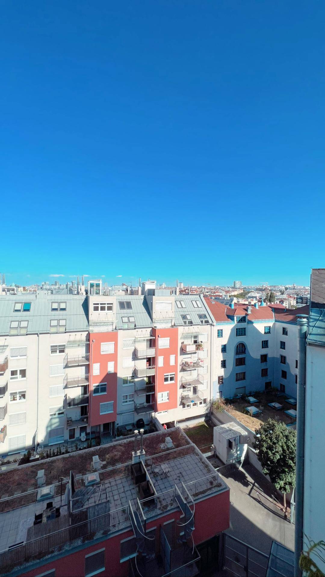 Weitblick über die Dächer der Stadt unter strahlend blauem Himmel.