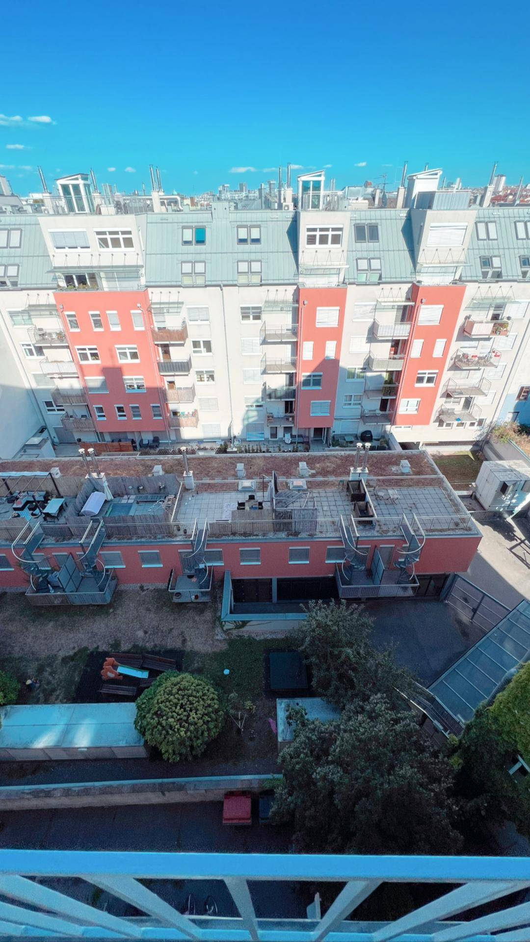 Panoramablick auf städtische Gebäude und Dächer mit etwas Grün.