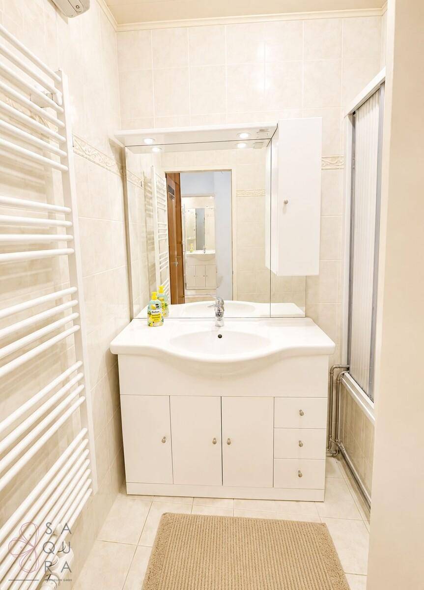 Badezimmer mit Waschbecken, Spiegelschrank und einem beheizten Handtuchhalter.