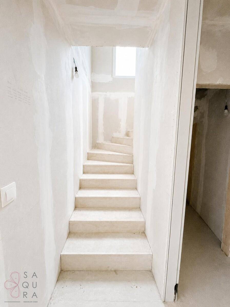 Unfertige Treppe mit Oberlicht, bereit für den Ausbau und die Endbearbeitung.