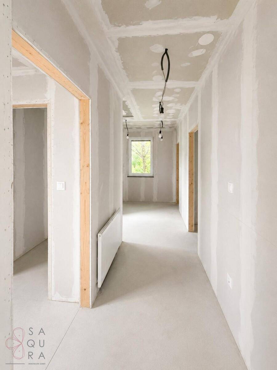 Unfertiger Flur mit Fenster und Heizkörper, bereit für den weiteren Ausbau.