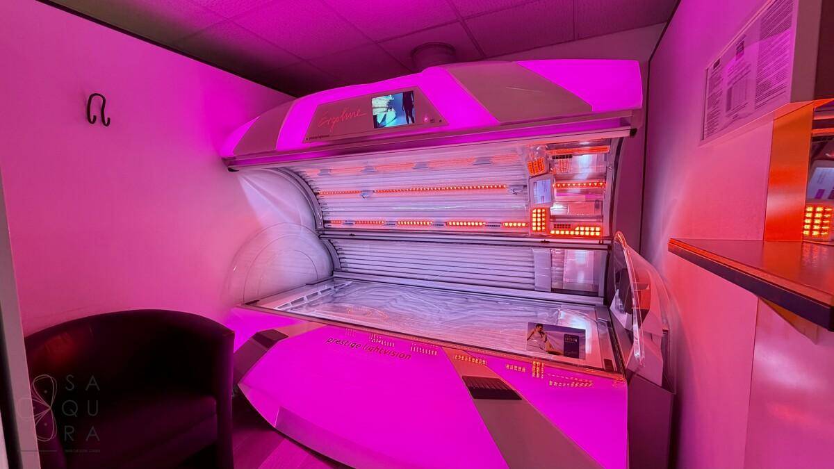 Solariumkabine mit intensivem pinkfarbenem Licht und modernem Bräunungsgerät für eine effektive Bräunung.