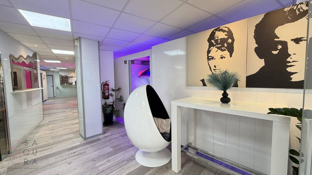 Moderner Wartebereich mit Design-Sessel, Pop-Art-Bildern und heller Beleuchtung.