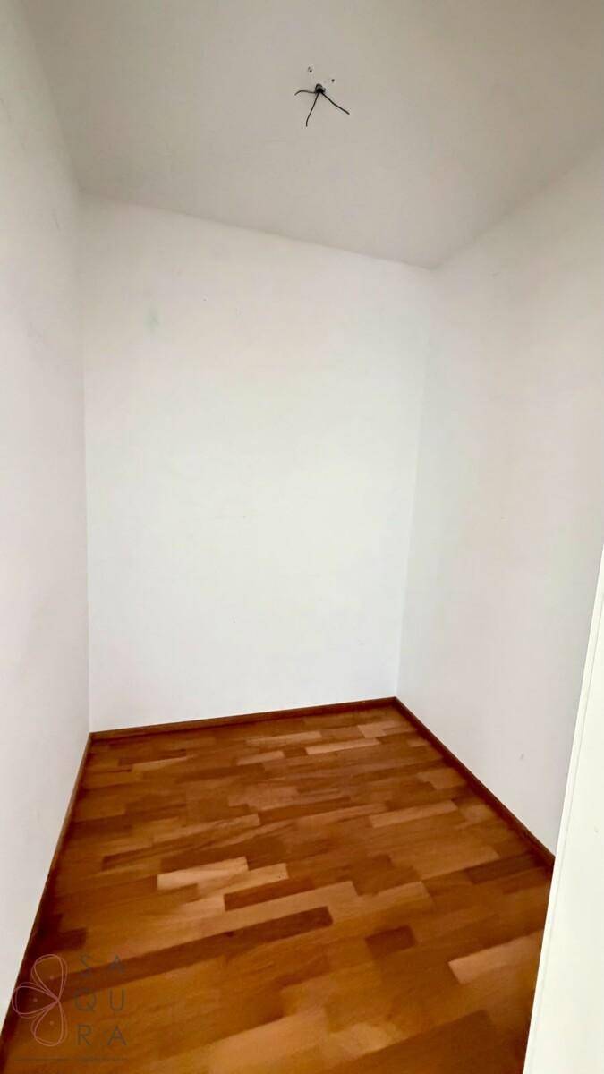 Kleiner Abstellraum mit Holzboden und weißen Wänden, ideal für zusätzlichen Stauraum.