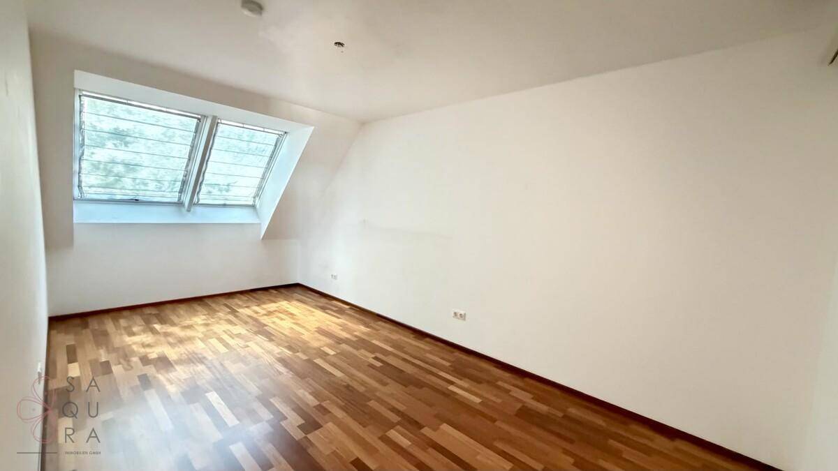Ruhiges Zimmer mit Holzboden und Dachfenstern, perfekt als Schlaf- oder Arbeitszimmer.
