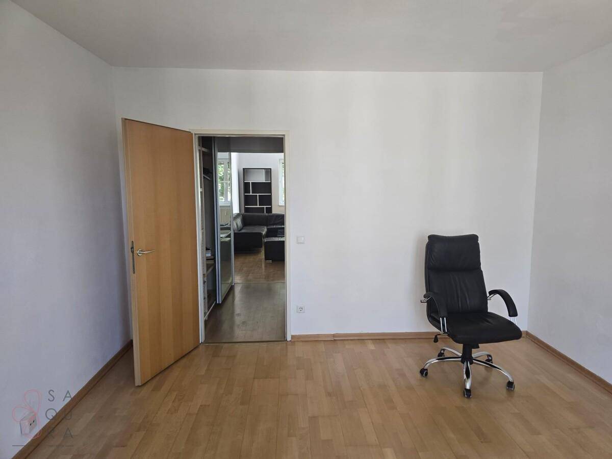 Geräumiges Zimmer mit Parkettboden und Bürostuhl, ideal als Arbeits- oder Gästezimmer nutzbar.