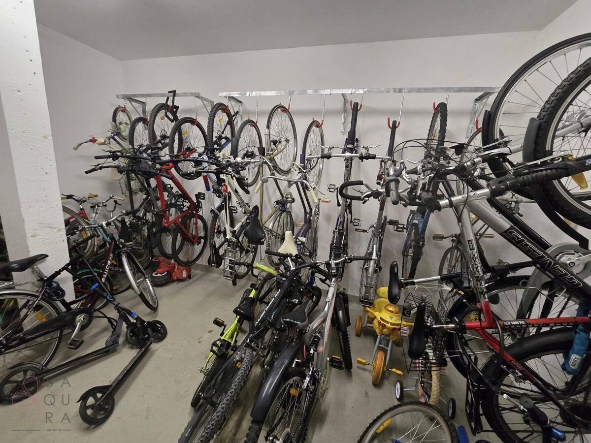 Geräumiger Fahrradraum mit vielen Abstellmöglichkeiten für Fahrräder und Roller.