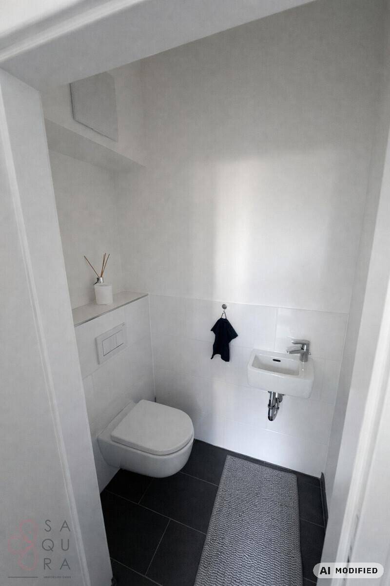Kleines Gäste-WC mit wandhängender Toilette und kompaktem Waschbecken.