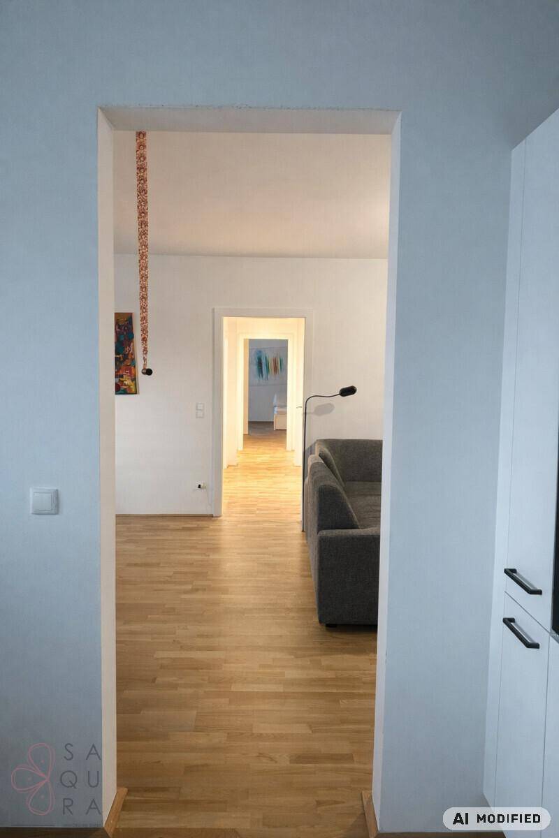 Heller Flur mit Holzboden, der in den Wohnbereich und weitere Räume führt.