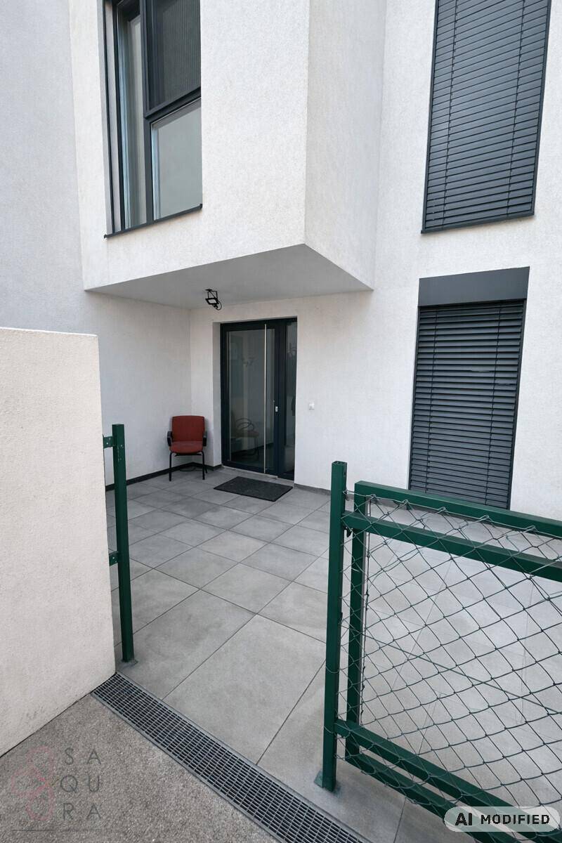 Gepflasterte Terrasse im Außenbereich mit einem Stuhl und einem Zaun.