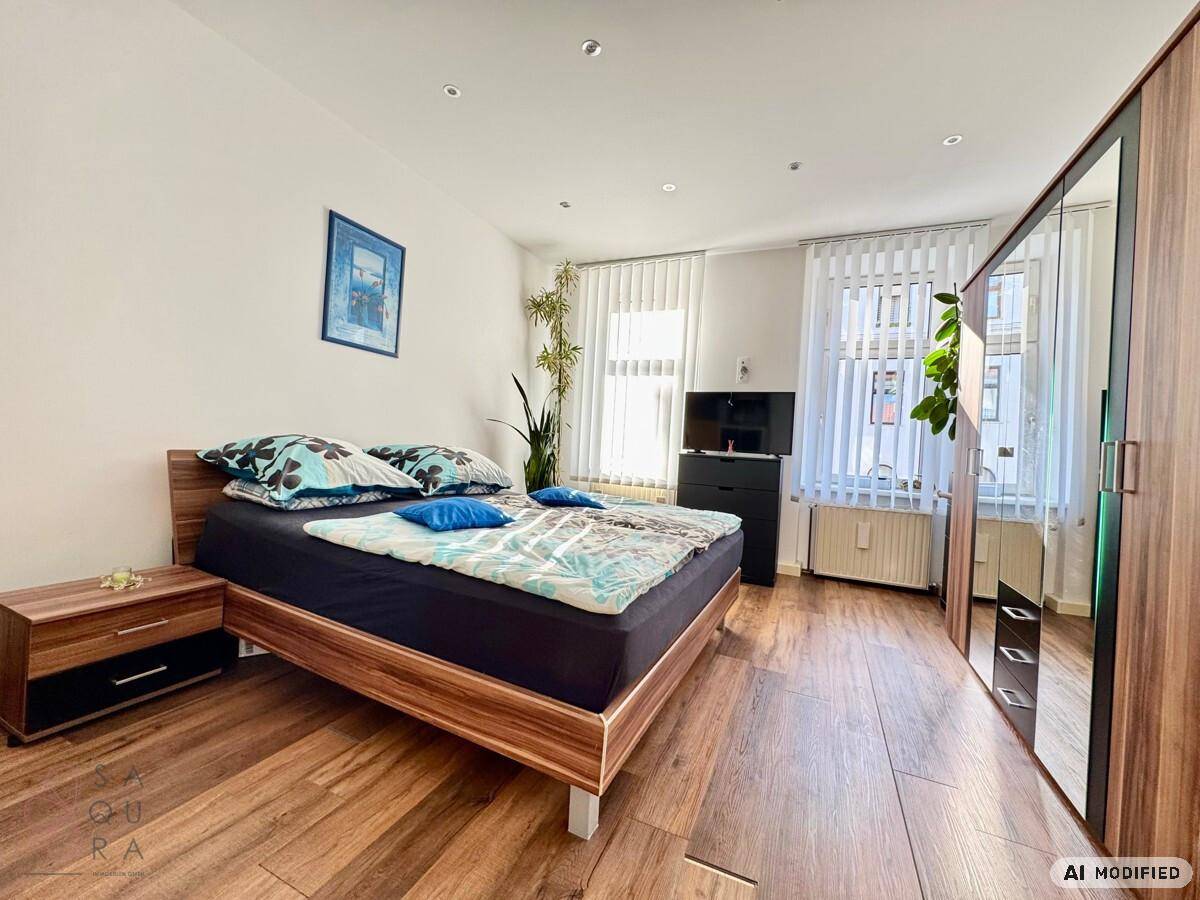 Helles Schlafzimmer mit Doppelbett, Nachttisch und großem Kleiderschrank.